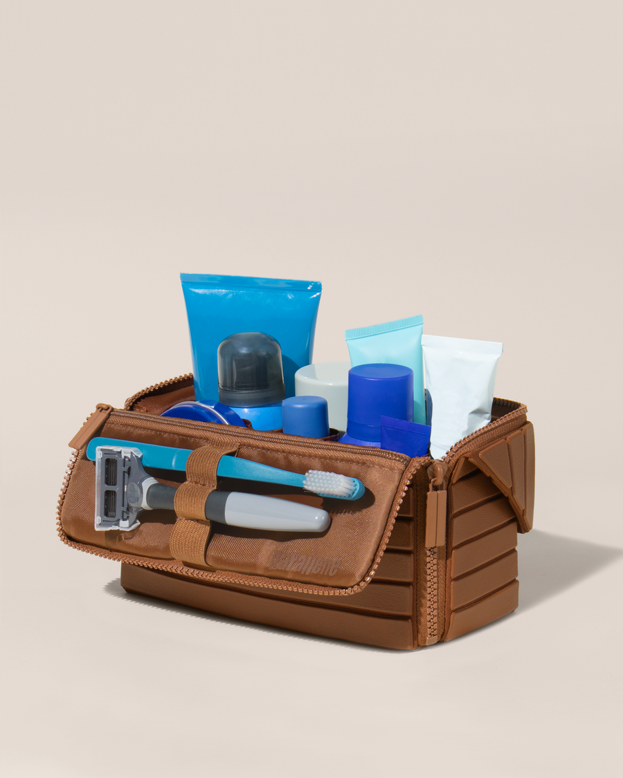 Open Parallelle Medium Vicuna (brown) Kit, shown open and packed with grooming essentials like razors, cologne, and skincare. A structured, travel-ready toiletry organizer