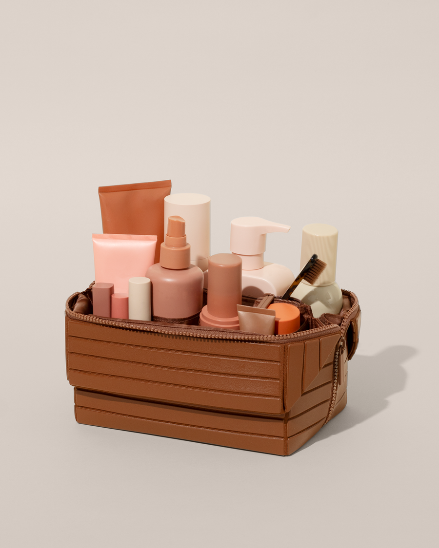 Open Parallelle Vicuna (brown) Kit, shown open and packed with skincare and grooming products. A compact, structured toiletry bag designed for visibility and access