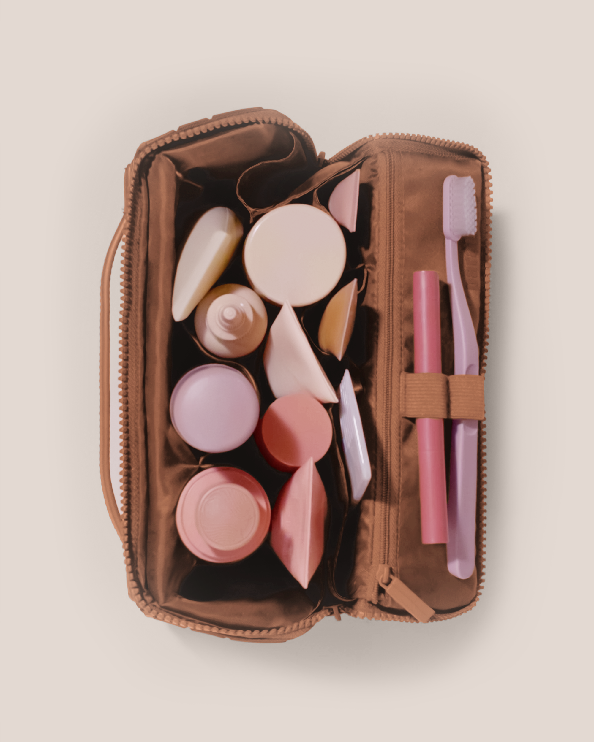 Overhead view of Parallelle Medium Vicuna (brown) Kit toiletry bag fully packed with upright toiletry products and organized compartments