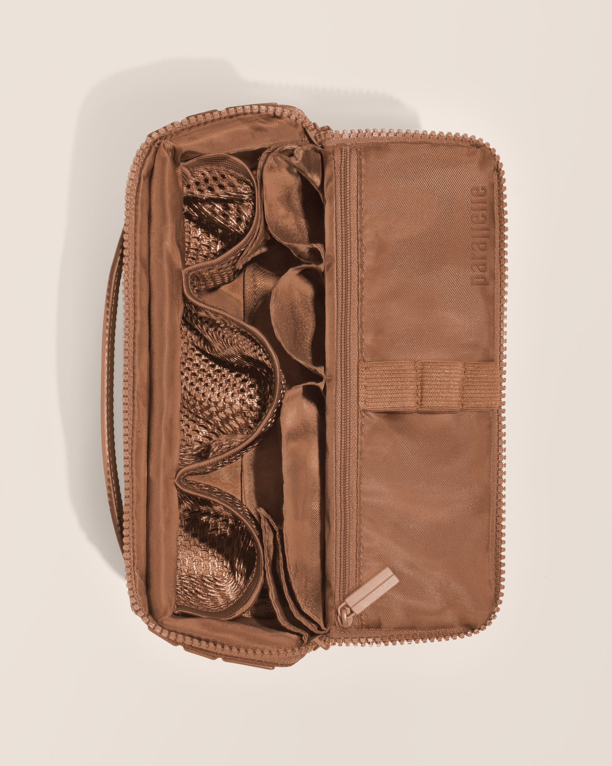 Overhead view of Parallelle Medium Vicuna (brown) Kit toiletry bag, showcasing its structured interior with multiple compartments and mesh pockets for organized travel storage