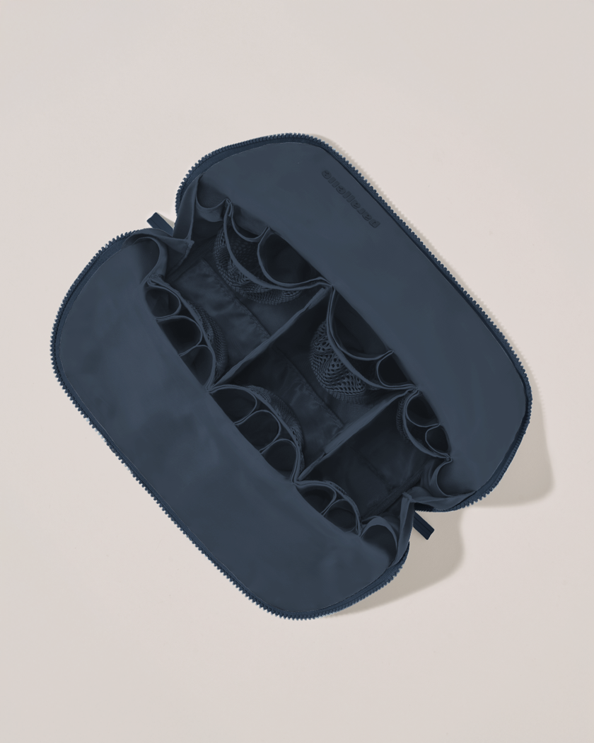 Interior view of Parallelle Large Indigo (navy) Traveller makeup bag showing empty pockets, pouches, and elastic holders