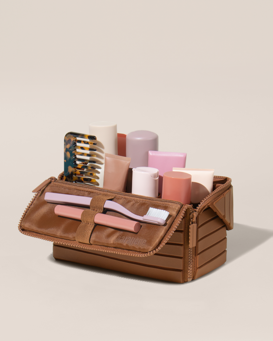Open Parallelle Medum Vicuna (brown) Kit, shown open and packed with skincare and grooming products. A compact, structured toiletry bag designed for visibility and access.