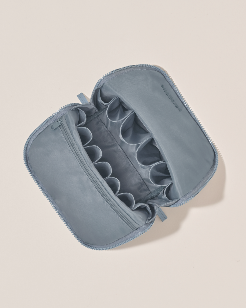 Interior view of Parallelle Slate (blue) Brush Traveller makeup bag showing empty pockets and pouches