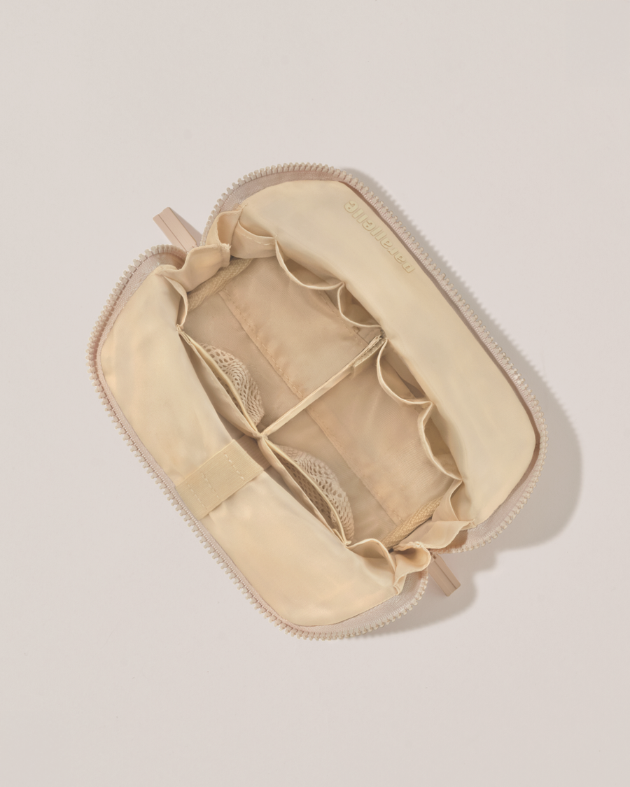 Interior view of Parallelle Small Bisque (white) Traveller makeup bag showing empty pockets, pouches, and elastic holders